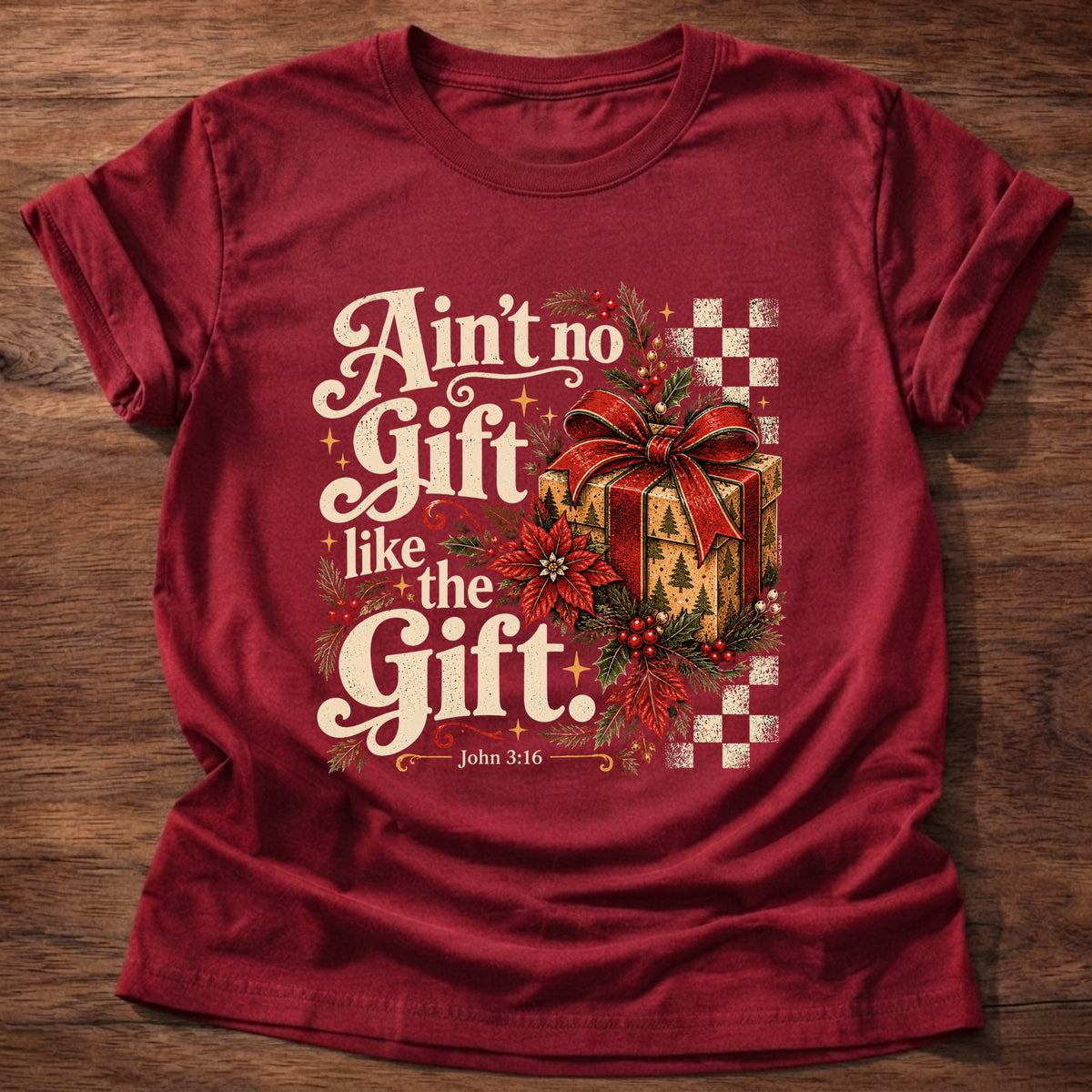 Cherry Red t-shirt printed with a retro wrapped Christmas present with poinsettias and checkerboard graphic and “Ain't no Gift like the Gift.” John 3:16 Christian shirt