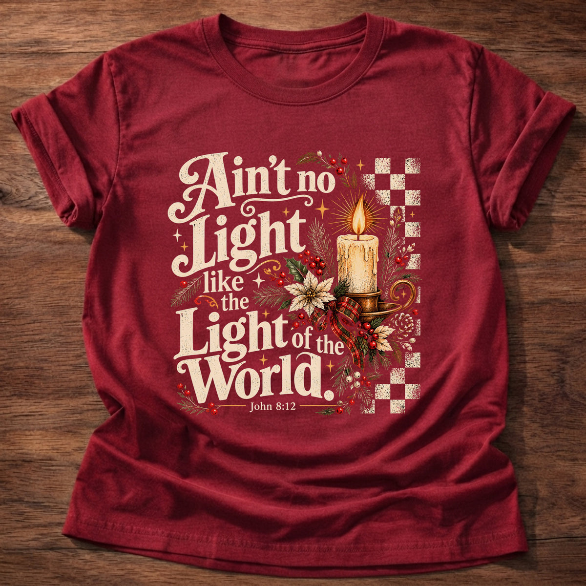 Cherry Red t-shirt printed with a retro glowing candle with poinsettias and checkerboard graphic and “Ain't no light like the Light of the World.” John 8:12 Christian shirt