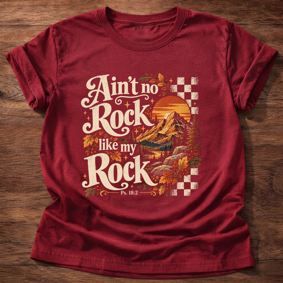 Cherry Red t-shirt printed with a retro mountain sunset with autumn leaves and checkerboard graphic and “Ain't no Rock like my Rock.” Psalm 18:2 Christian shirt