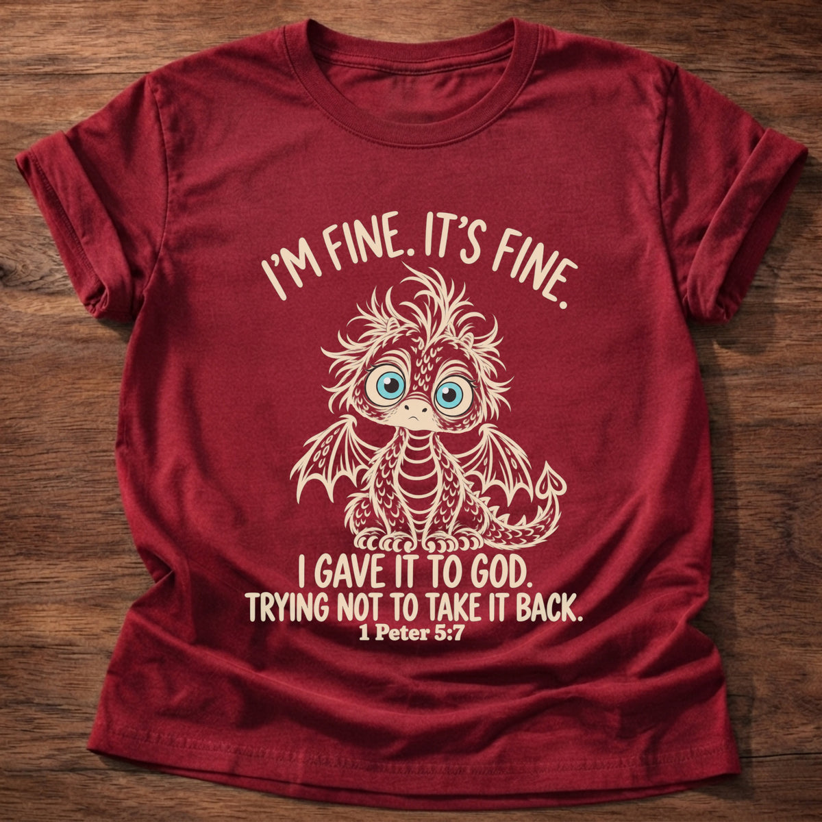 Cherry Red t-shirt printed with a wide-eyed, frazzled baby dragon graphic and “I'm fine. It's fine. I gave it to God. Trying not to take it back.” 1 Peter 5:7 Christian shirt