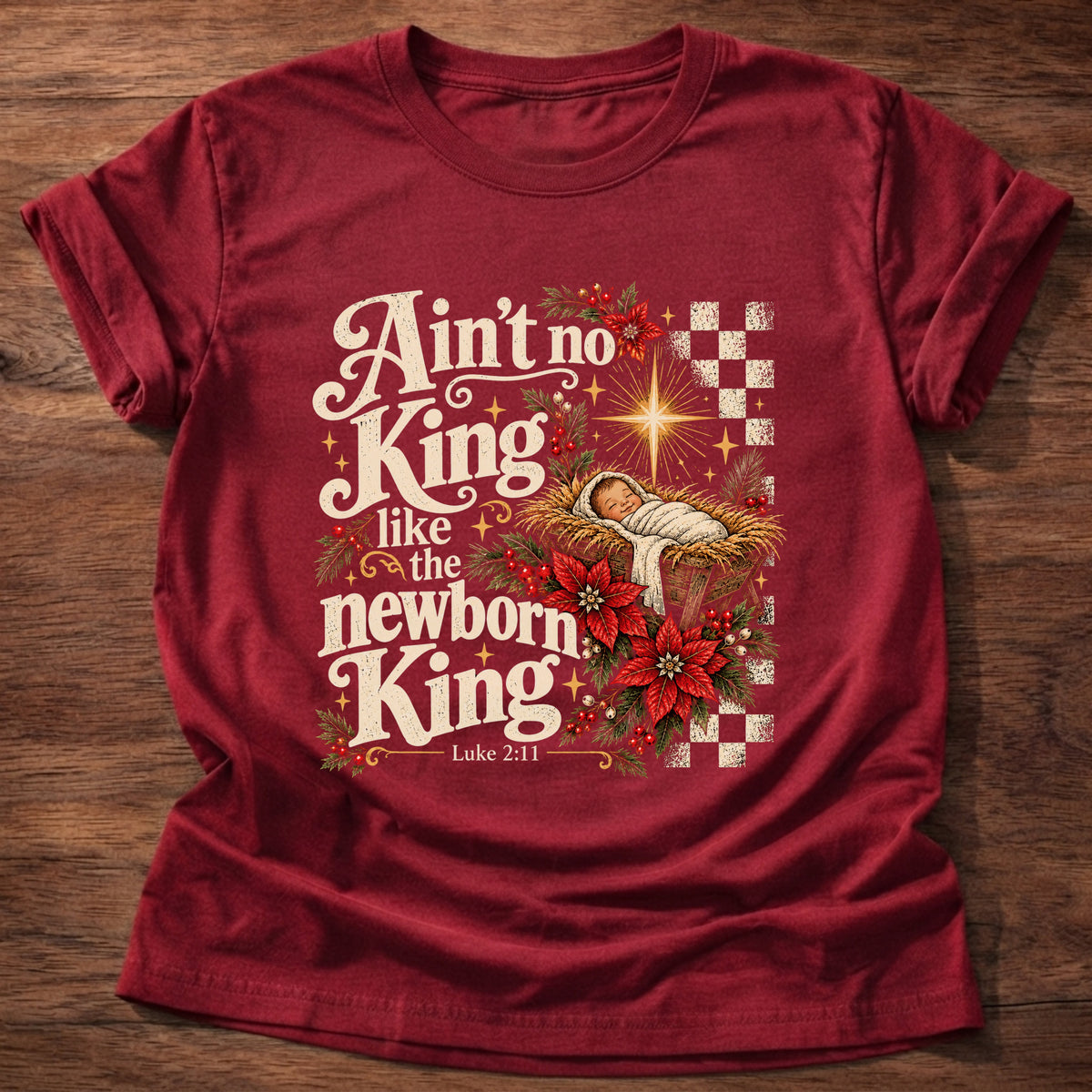 Cherry Red t-shirt printed with a retro manger scene with a star, poinsettias and checkerboard graphic and “Ain't no King like the newborn King.” Luke 2:11 Christian shirt