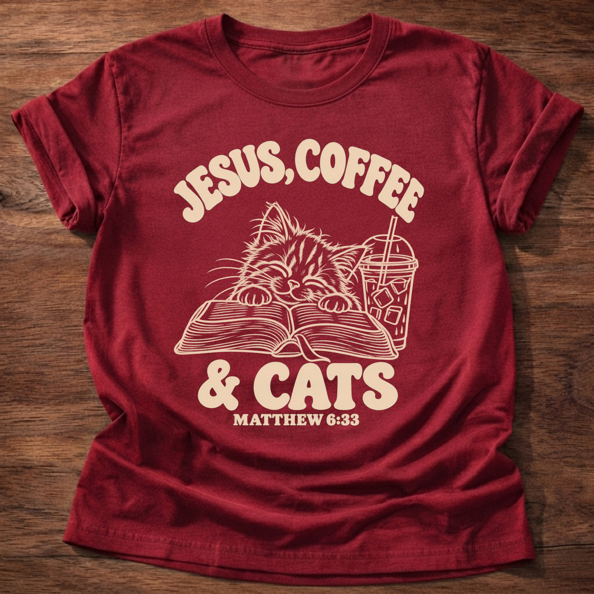 Cherry Red t-shirt printed with a kitten reading an open Bible beside an iced coffee and “Jesus, Coffee & Cats” Matthew 6:33 Christian shirt