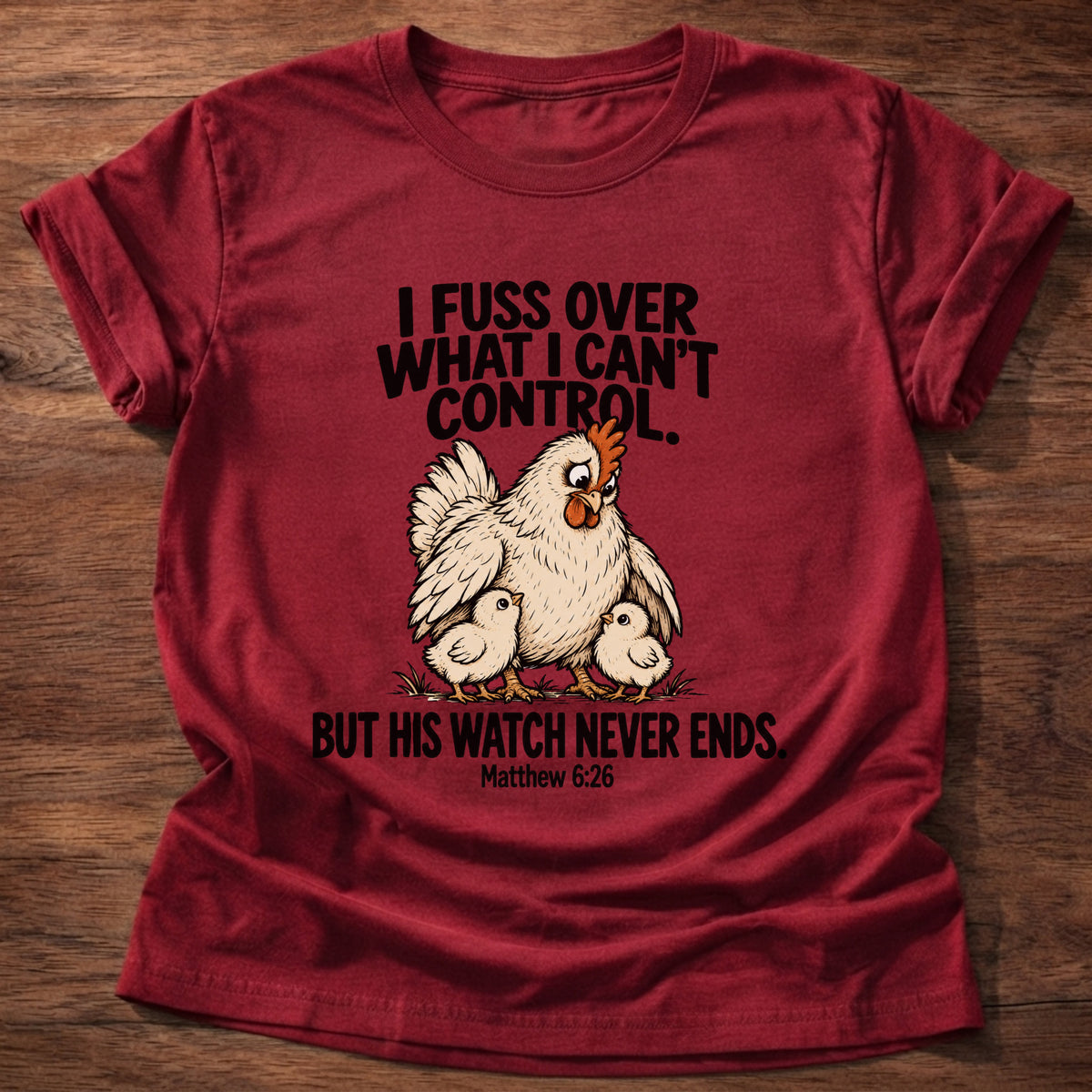 Cherry Red t-shirt printed with a fussing hen graphic and 'I fuss over what I can't control. But His watch never ends.' Matthew 6:26 faith based gift