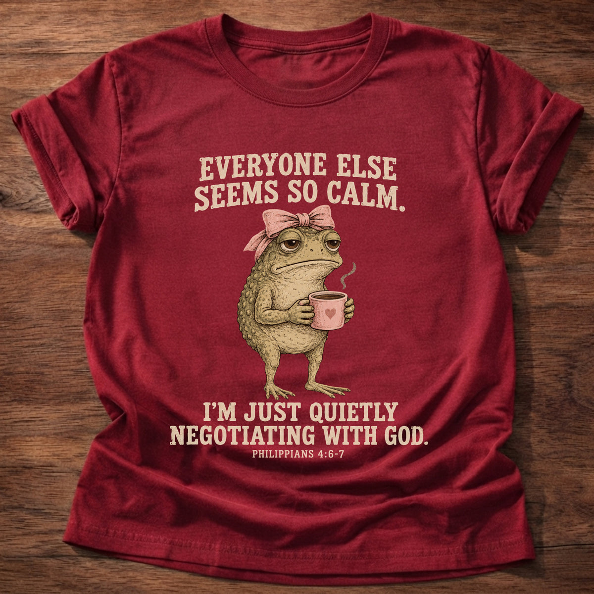 Cherry Red t-shirt printed with a possum holding a tea cup graphic and 'Everyone else seems so calm. I'm just quietly negotiating with God.' Philippians 4:6-7 faith based gift