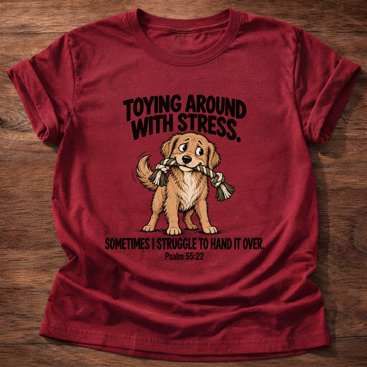 Cherry Red t-shirt printed with a dog tugging a rope toy graphic and 'Toying around with stress. Sometimes I struggle to hand it over.' Psalm 55:22 faith based gift