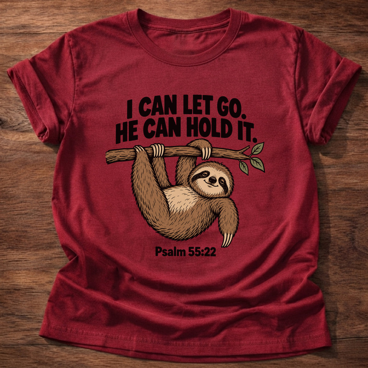 Cherry Red t-shirt printed with a sloth hanging from a branch graphic and 'I can let go. He can hold it.' Psalm 55:22 faith based gift