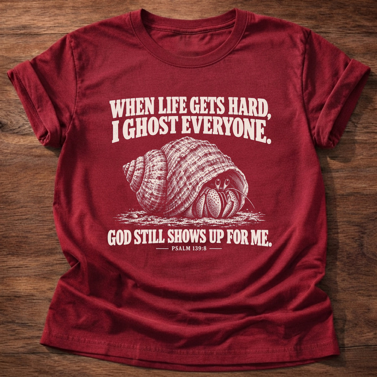 Cherry Red t-shirt printed with a hermit crab retreating into its shell graphic and 'When life gets hard, I ghost everyone. God still shows up for me.' Psalm 139:8 faith based gift