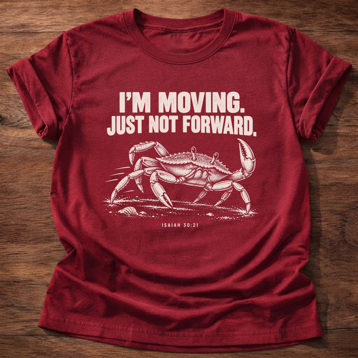 Cherry Red t-shirt printed with a crab scuttling sideways across the sand graphic and 'I'm moving. Just not forward.' Isaiah 30:21 faith based gift