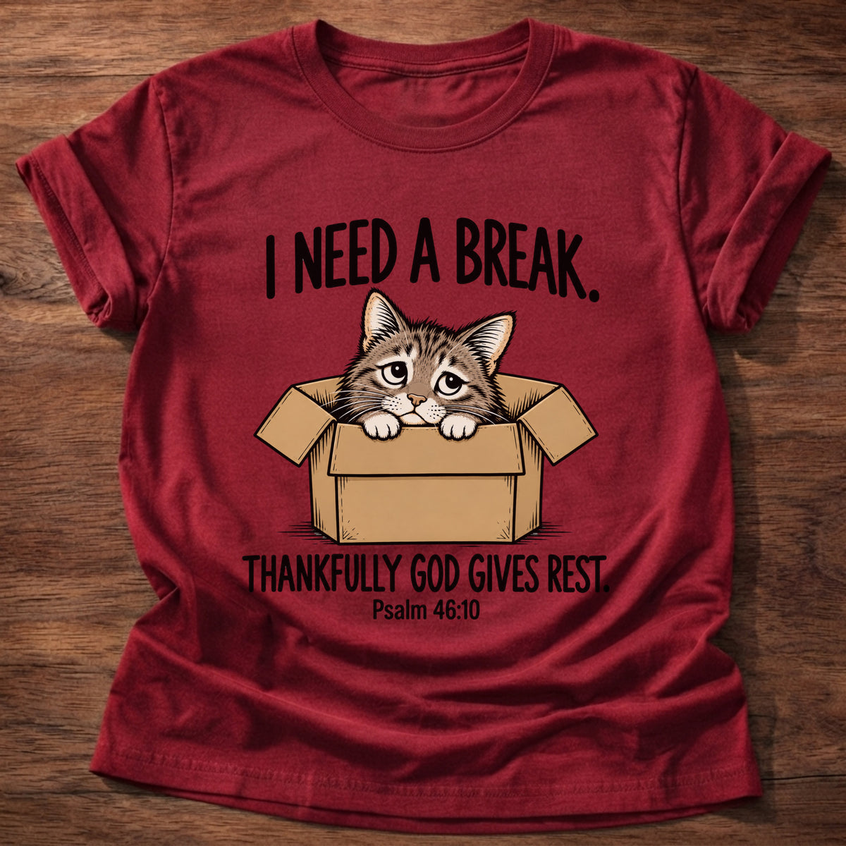 Cherry Red t-shirt printed with a cat curled in a cardboard box graphic and 'I need a break. Thankfully God gives rest.' Psalm 46:10 faith based gift