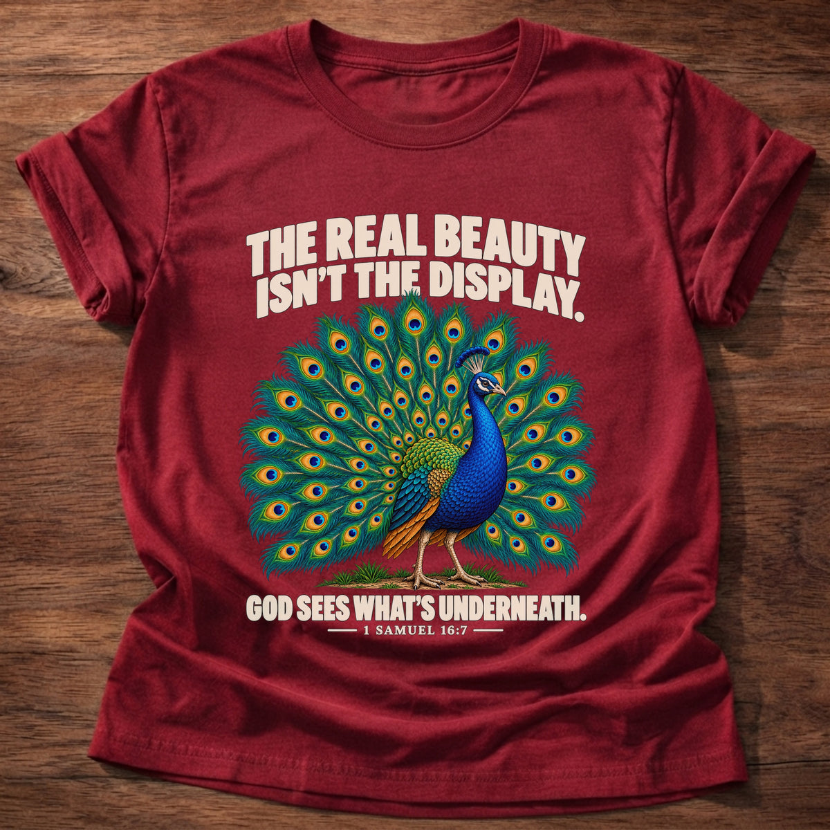 Cherry Red t-shirt printed with a peacock with feathers in full display graphic and 'The real beauty isn't the display. God sees what's underneath.' 1 Samuel 16:7 faith based gift
