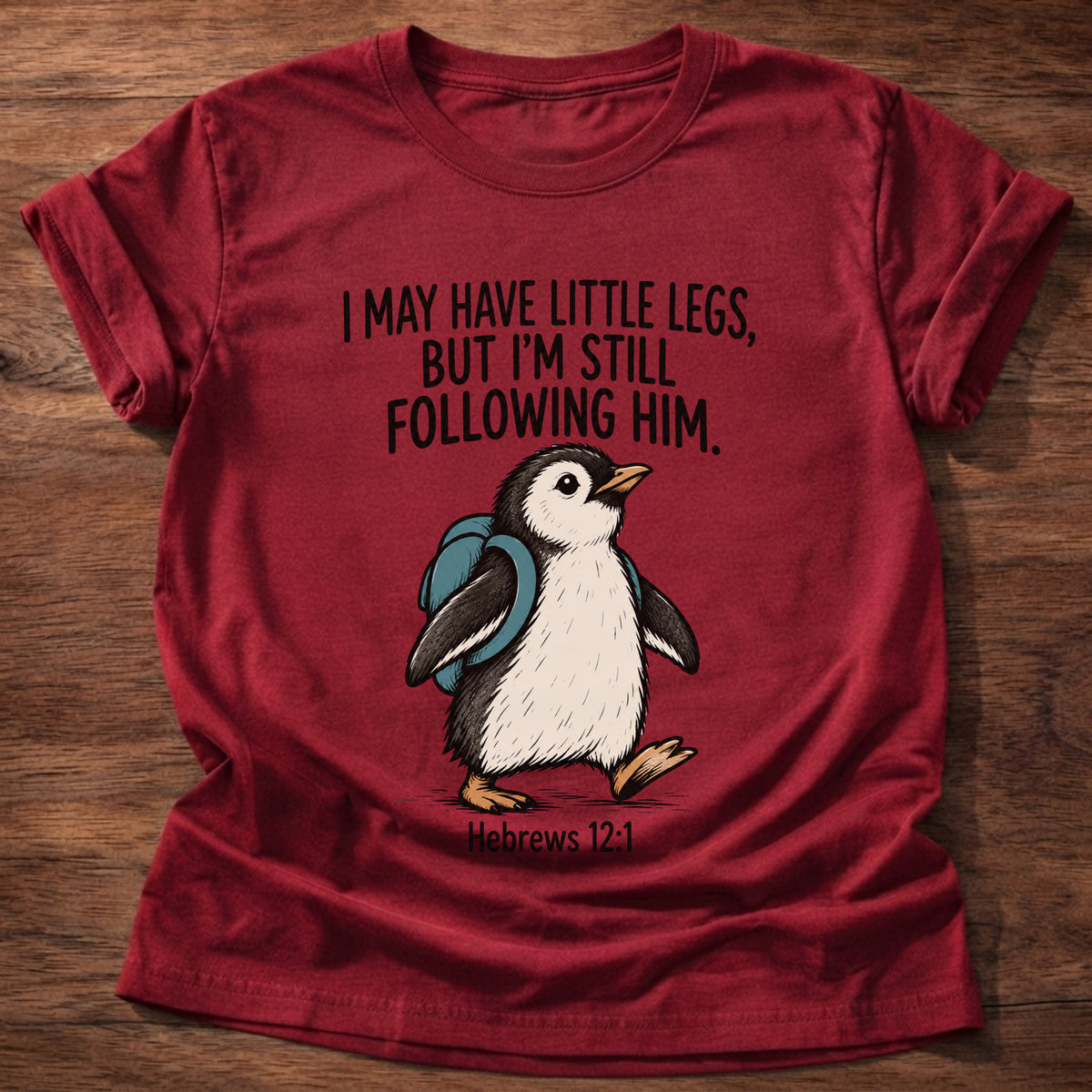 Cherry Red t-shirt printed with a penguin graphic and 'I may have little legs, but I'm still following Him.' Hebrews 12:1 faith based gift