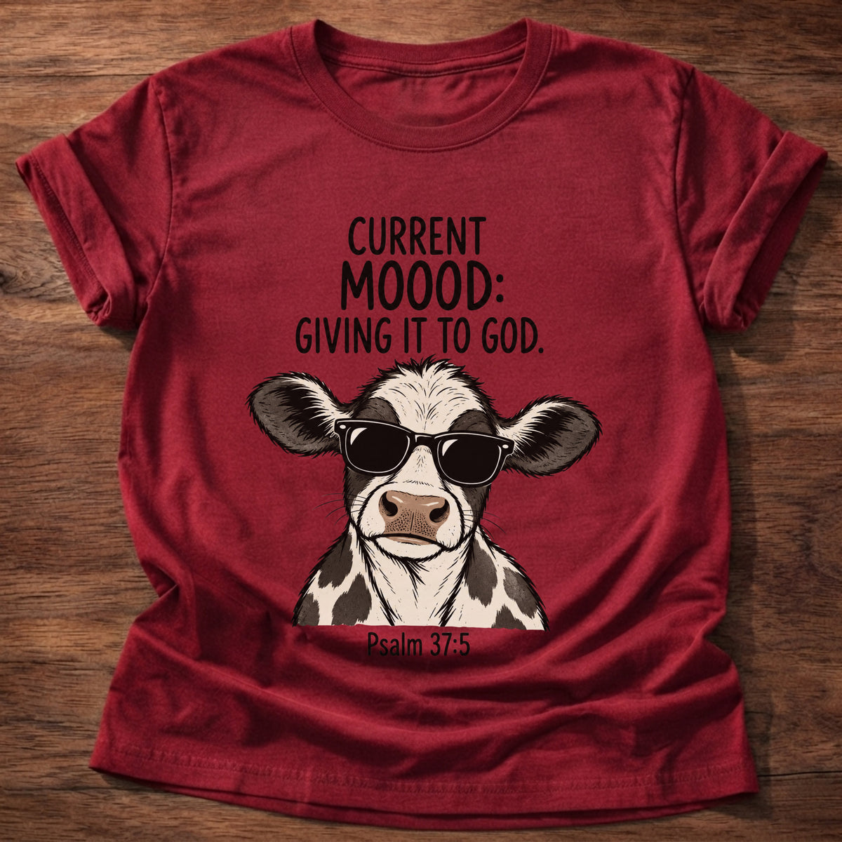 Cherry Red t-shirt printed with a sunglasses-wearing cow graphic and 'Current moood: giving it to God.' Psalm 55:22 faith based gift