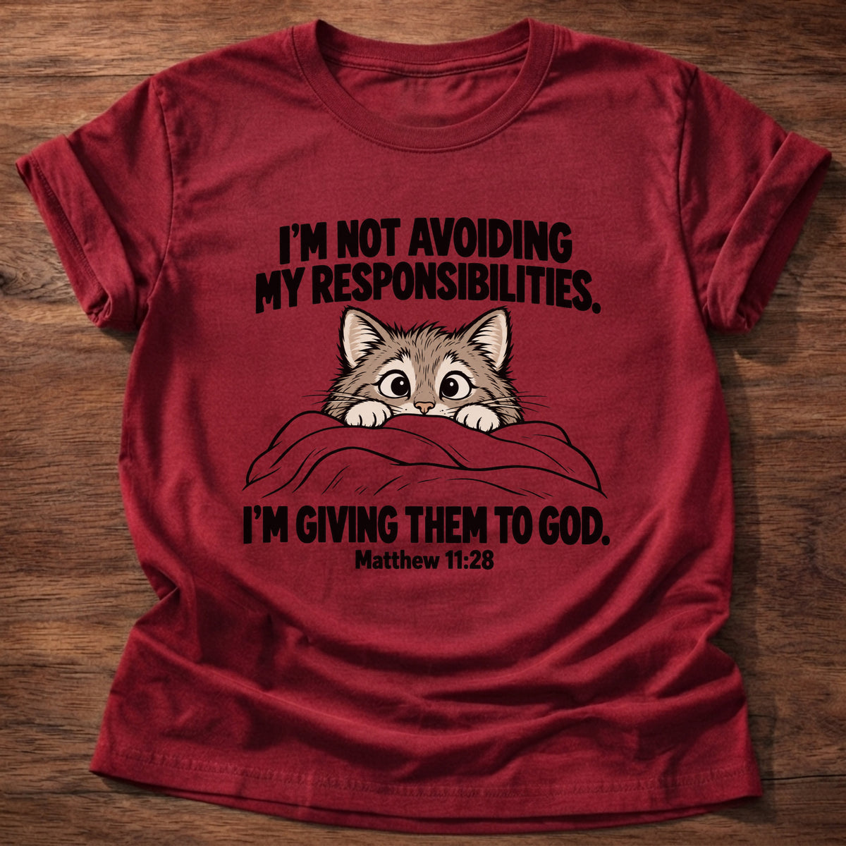 Cherry Red t-shirt printed with a cat peeking over a blanket graphic and 'I'm not avoiding my responsibilities. I'm giving them to God.' Matthew 11:28 faith based gift