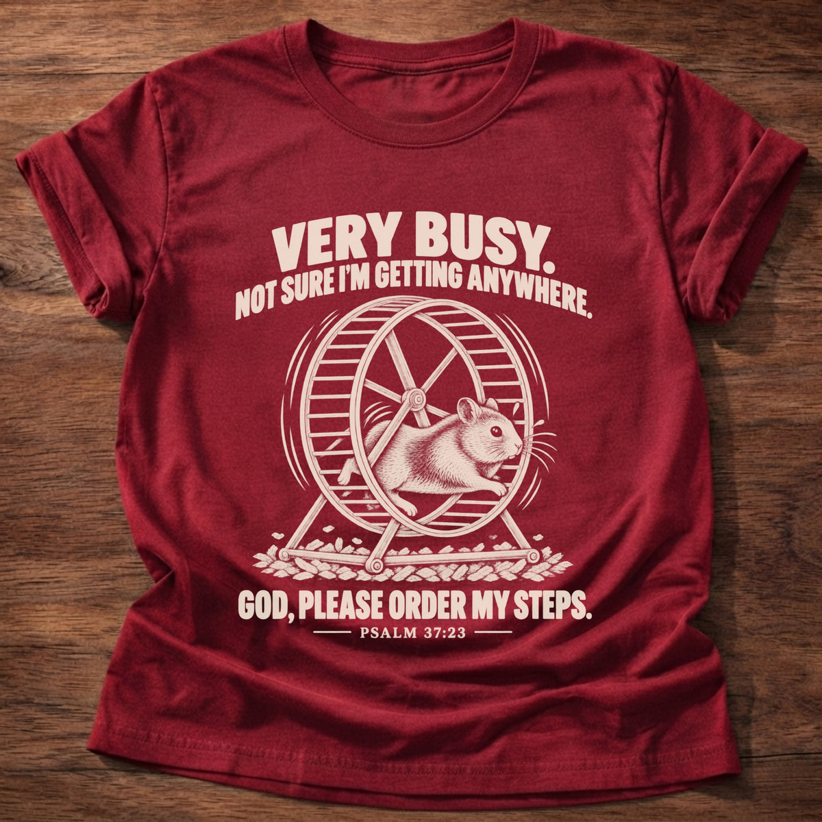 Cherry Red t-shirt printed with a squirrel running on a wheel graphic and 'Very busy. Not sure I'm getting anywhere. God, please order my steps.' Psalm 37:23 faith based gift