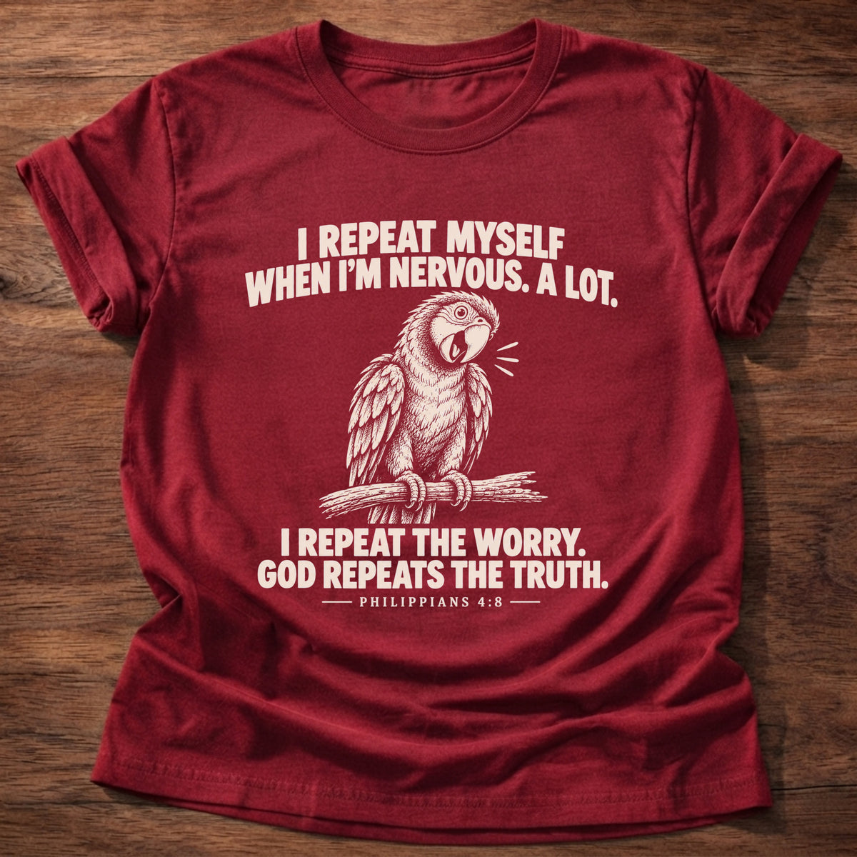 Cherry Red t-shirt printed with a parrot squawking on a perch graphic and 'I repeat myself when I'm nervous. A lot. I repeat the worry. God repeats the truth.' Philippians 4:6 faith based gift