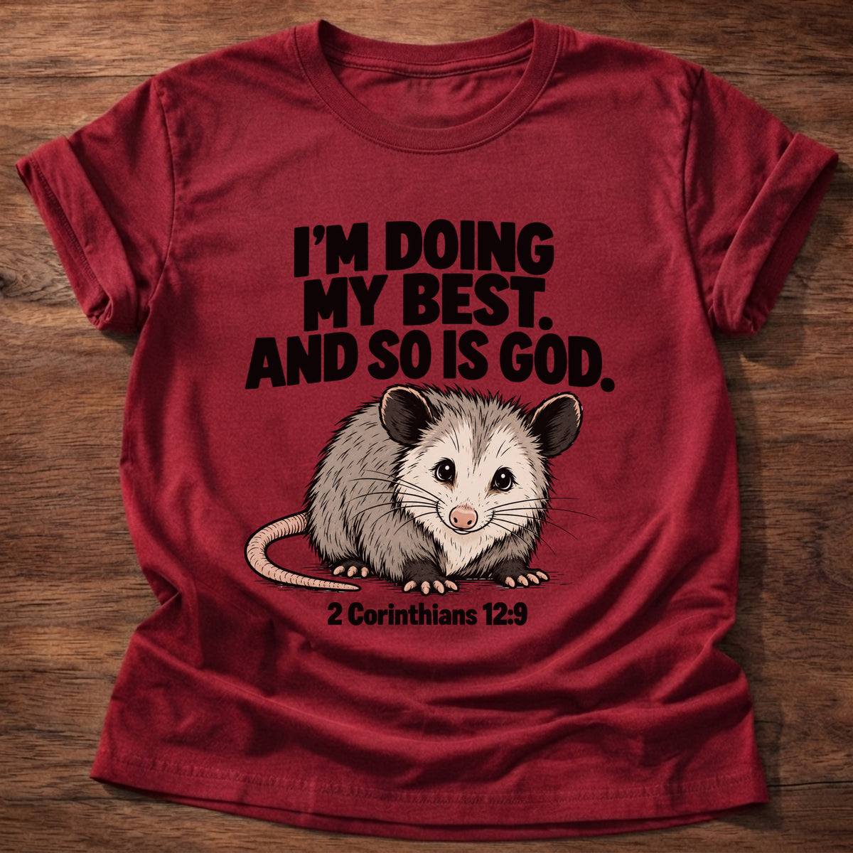 Cherry Red t-shirt printed with an opossum graphic and 'I'm doing my best. And so is God.' 2 Corinthians 12:9 faith based gift