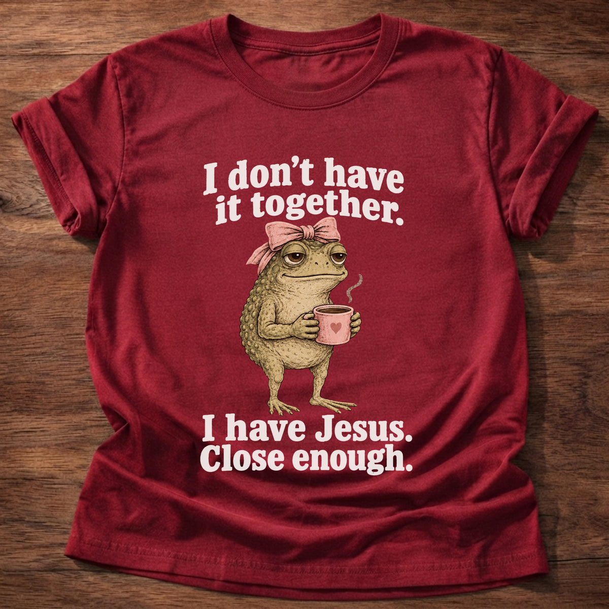 Cherry Red t-shirt printed with a frog holding a tea cup graphic and 'I don't have it together. I have Jesus. Close enough.' 2 Corinthians 12:9 faith based gift