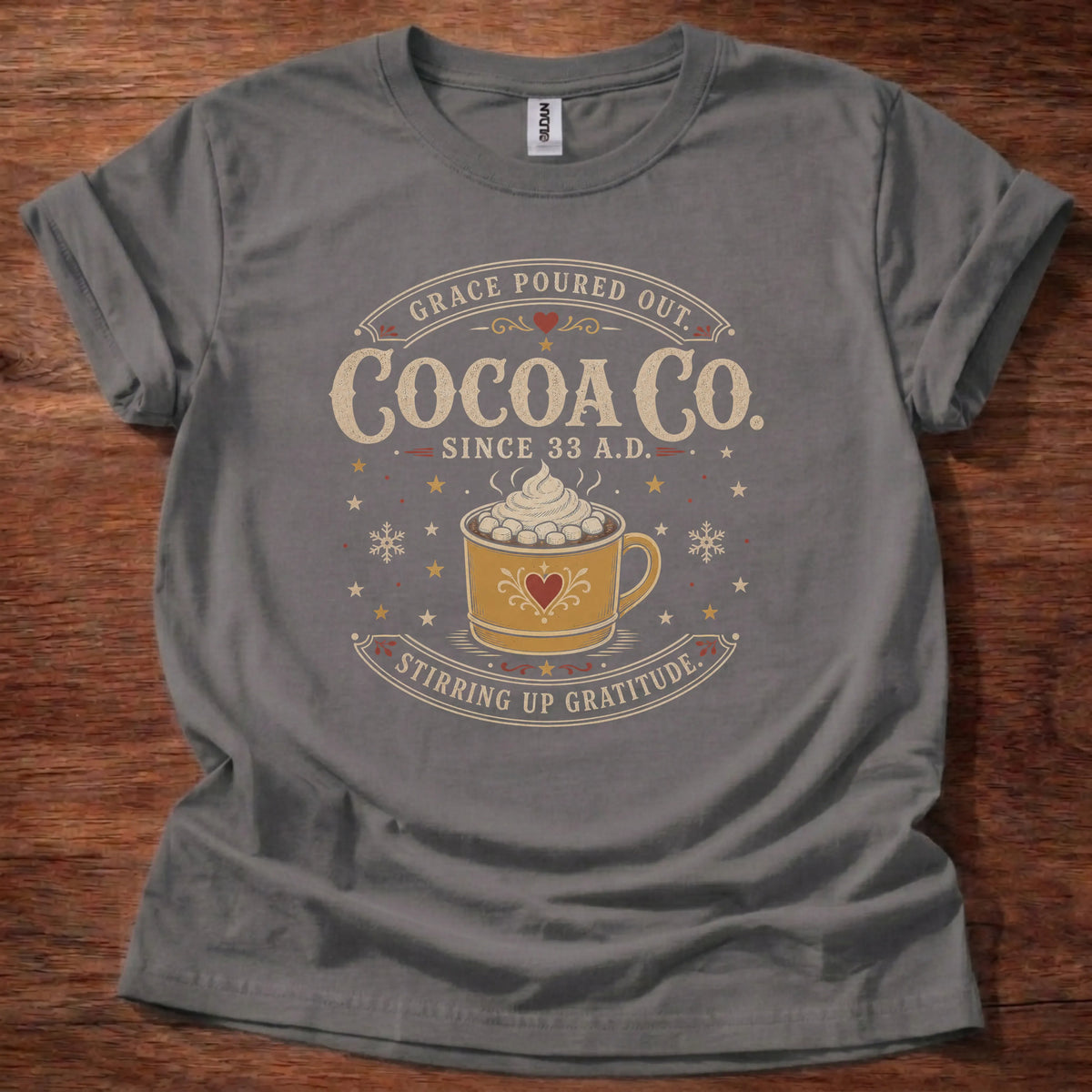 Charcoal t-shirt with a vintage cocoa shop sign design reading Grace Poured Out, Cocoa Co, Since 33 A.D., Stirring Up Gratitude