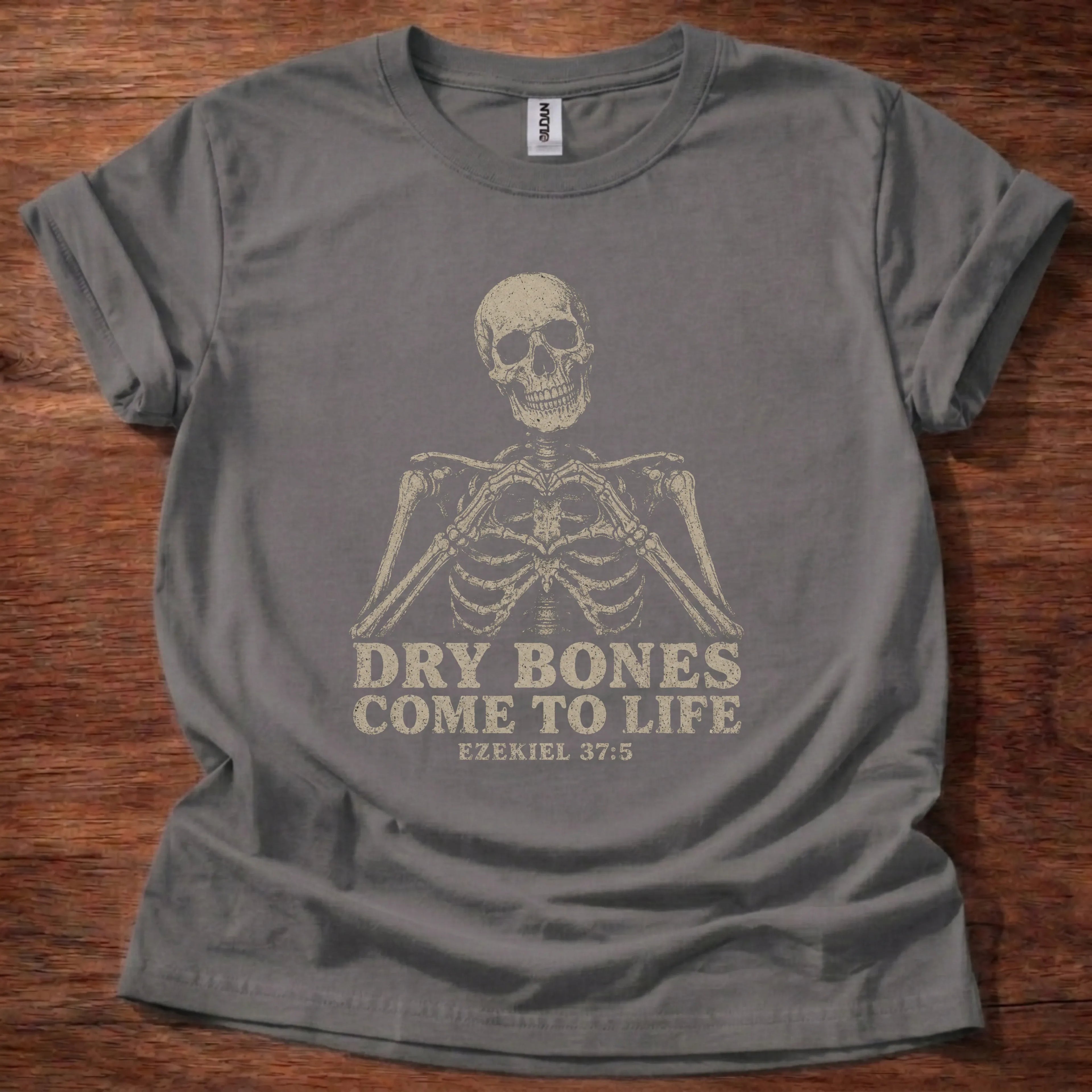 Charcoal t-shirt with a solo distressed skeleton bust above bold block text reading Dry Bones Come to Life, Ezekiel 37:5