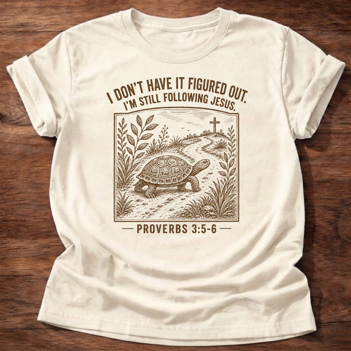 Natural colored t-shirt with turtle illustration reading 'I don't have it figured out. I'm still following Jesus' Christian shirt