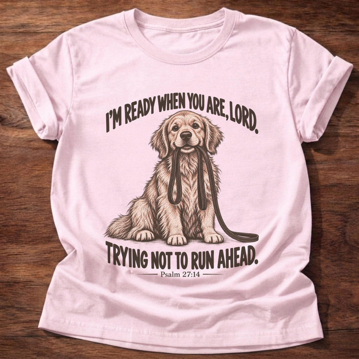 Light Pink t-shirt printed with a golden retriever sitting with its leash in its mouth graphic and “I'm ready when you are, Lord. Trying not to run ahead.” Psalm 27:14 faith based gift