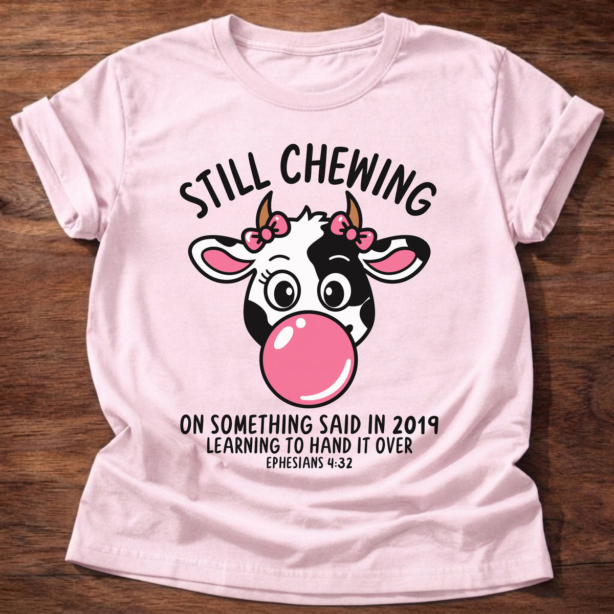 Light Pink t-shirt printed with a cow blowing a bubblegum bubble and “Still chewing on something said in 2019. Learning to hand it over.” Ephesians 4:32 Christian shirt