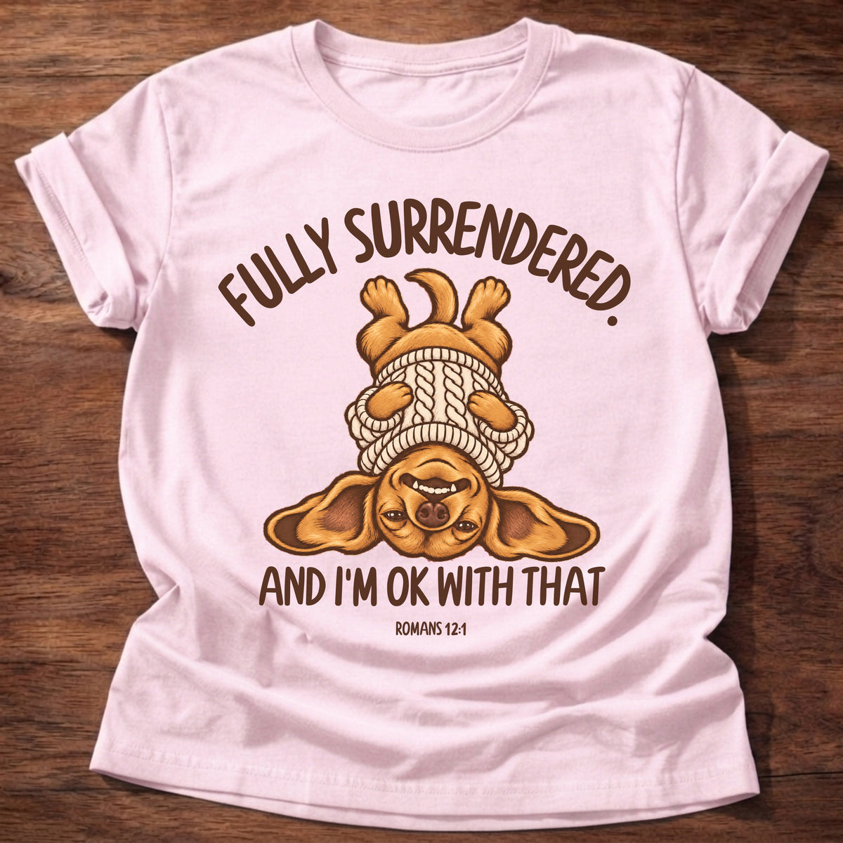 Light Pink t-shirt printed with an upside-down puppy in a cozy sweater and “Fully surrendered. And I'm OK with that.” Romans 12:1 Christian shirt