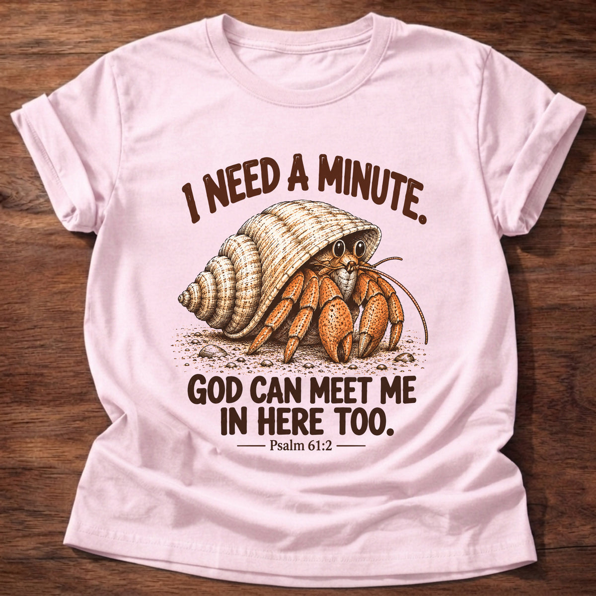 Light Pink t-shirt printed with a hermit crab peeking out of its spiral shell graphic and “I need a minute. God can meet me in here too.” Psalm 61:2 faith based gift