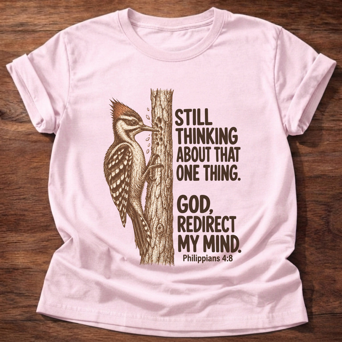 Light Pink t-shirt printed with a woodpecker pecking at a tree trunk graphic and “Still thinking about that one thing. God, redirect my mind.” Philippians 4:8 faith based gift