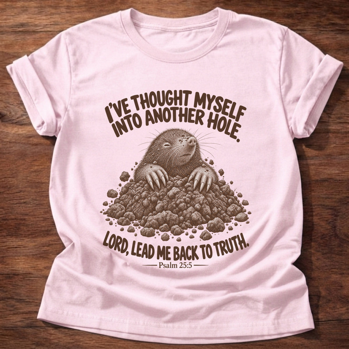 Light Pink t-shirt printed with a mole poking out of a mound of dirt graphic and “I've thought myself into another hole. Lord, lead me back to truth.” Psalm 25:5 faith based gift