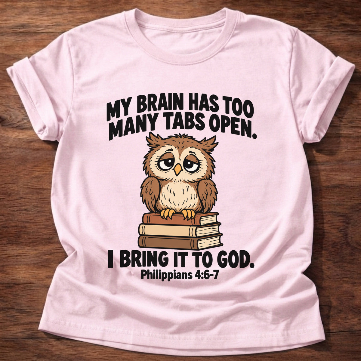 Light Pink t-shirt printed with an owl surrounded by books graphic and 'My brain has too many tabs open. I bring it to God.' Philippians 4:6-7 faith based gift