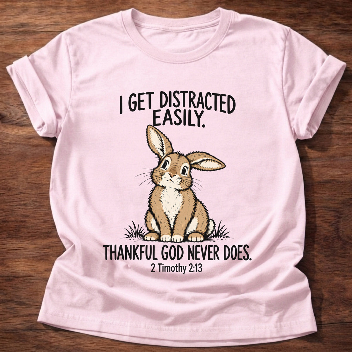 Light Pink t-shirt printed with a rabbit graphic and 'I get distracted easily. Thankful God never does.' 2 Timothy 2:13 faith based gift
