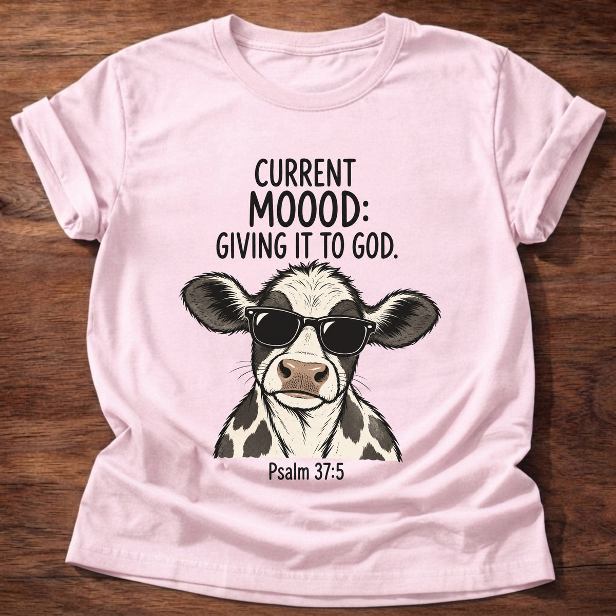 Light Pink t-shirt printed with a sunglasses-wearing cow graphic and 'Current moood: giving it to God.' Psalm 55:22 faith based gift