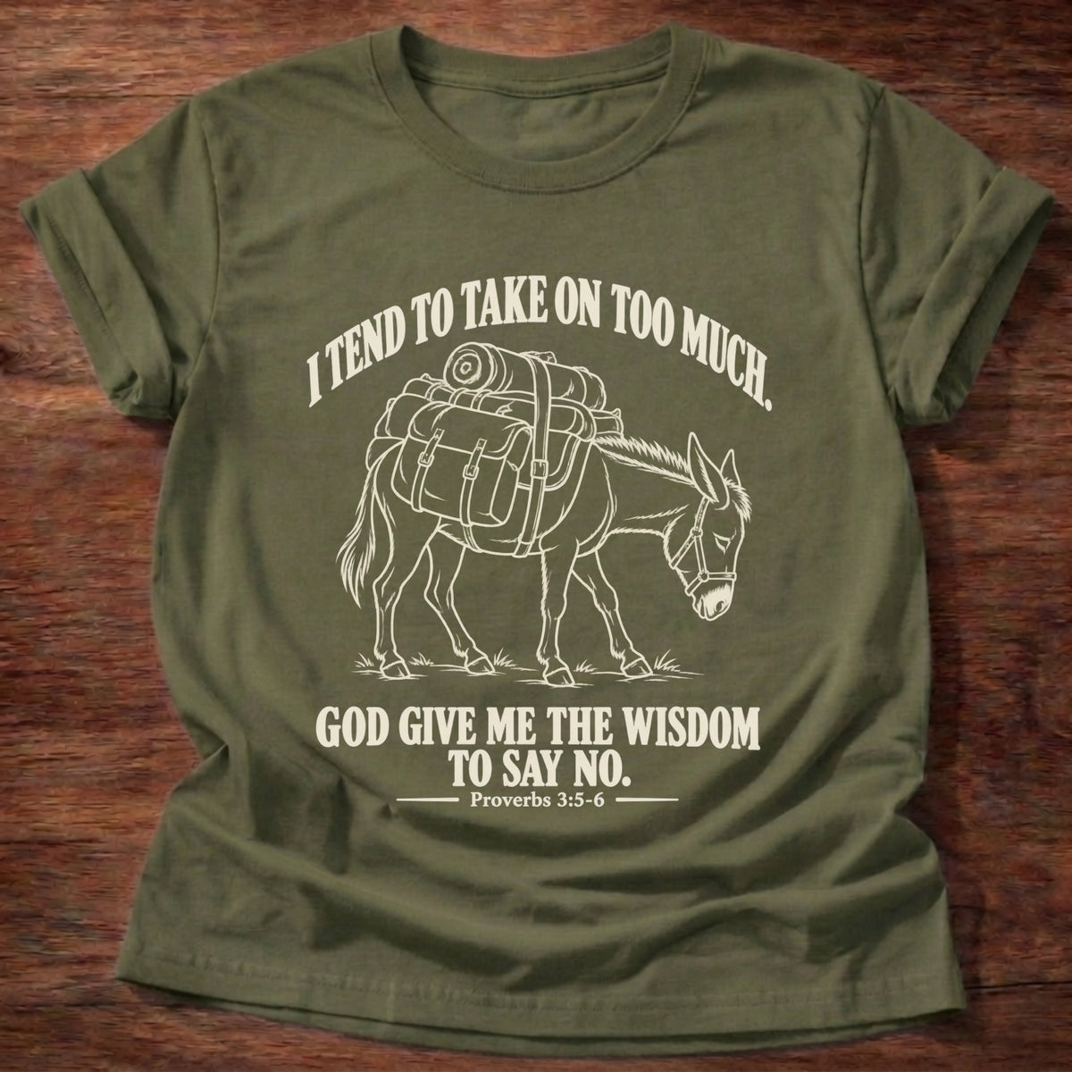 Military Green t-shirt printed with a pack donkey weighed down with overstuffed bags and bundles graphic and “I tend to take on too much. God give me the wisdom to say no.” Proverbs 3:5-6 faith based gift