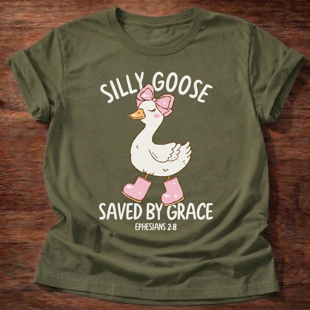 Military Green t-shirt printed with a goose wearing a pink bow and pink boots and “Silly Goose. Saved by Grace.” Ephesians 2:8 Christian shirt