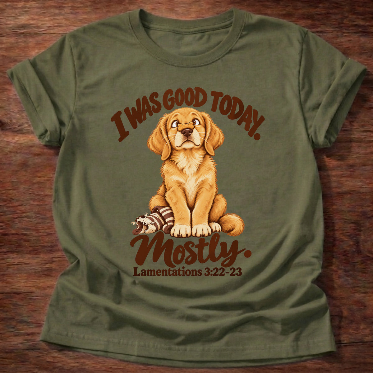 Military Green t-shirt printed with a golden retriever puppy sitting beside a chewed-up toy and “I was good today. Mostly.” Lamentations 3:22-23 Christian shirt