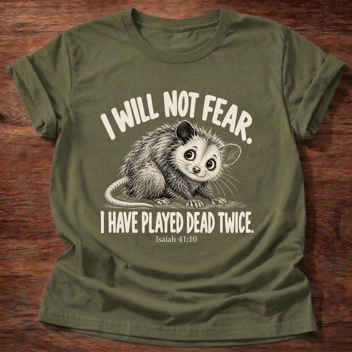 Military Green t-shirt printed with a wide-eyed opossum graphic and “I will not fear. I have played dead twice.” Isaiah 41:10 Christian shirt
