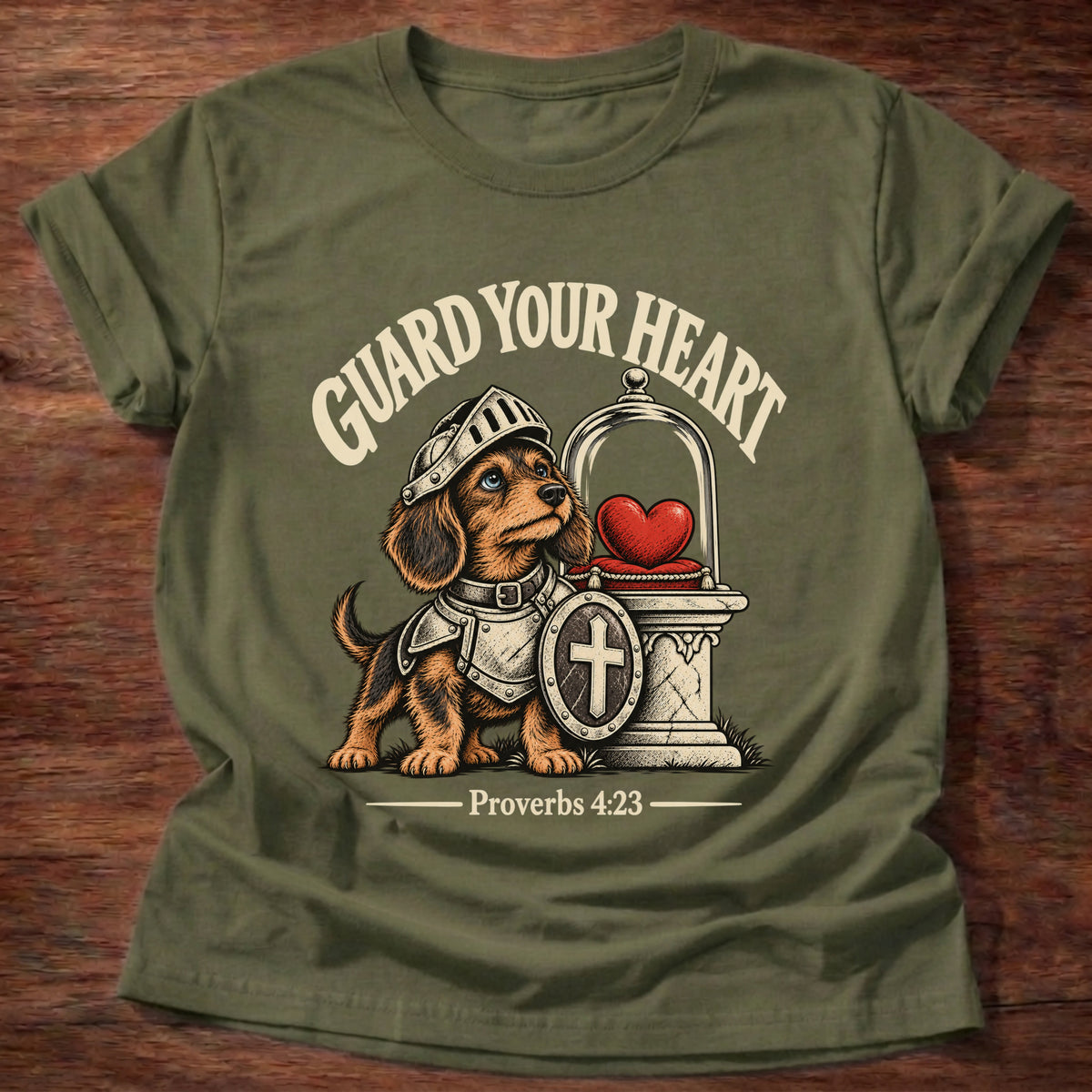 Military Green t-shirt printed with a brave knight dachshund in armor guarding a glowing heart graphic and “Guard your heart.” Proverbs 4:23 Christian shirt