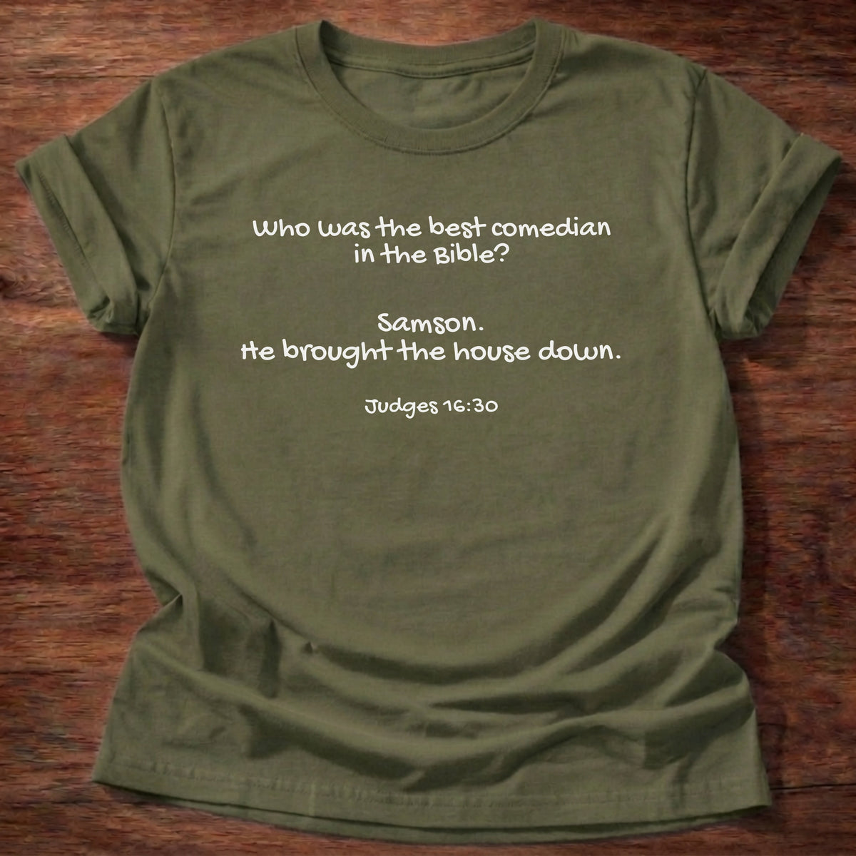 Military Green t-shirt printed with a simple hand-lettered Bible joke graphic and “Who was the best comedian in the Bible? Samson. He brought the house down.” Judges 16:30 Christian shirt