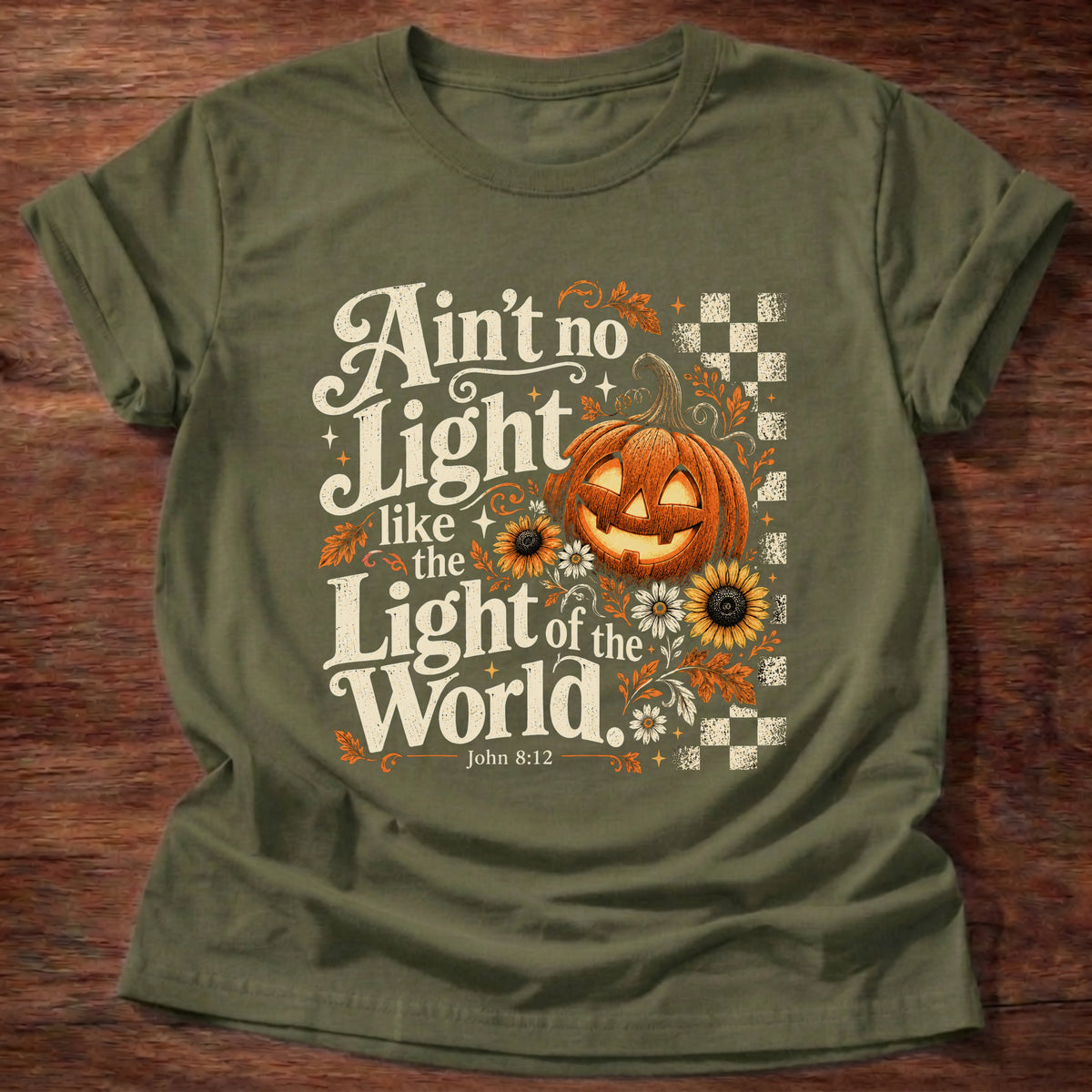 Military Green t-shirt printed with a retro glowing jack-o'-lantern with sunflowers and checkerboard graphic and “Ain't no light like the Light of the World.” John 8:12 Christian shirt