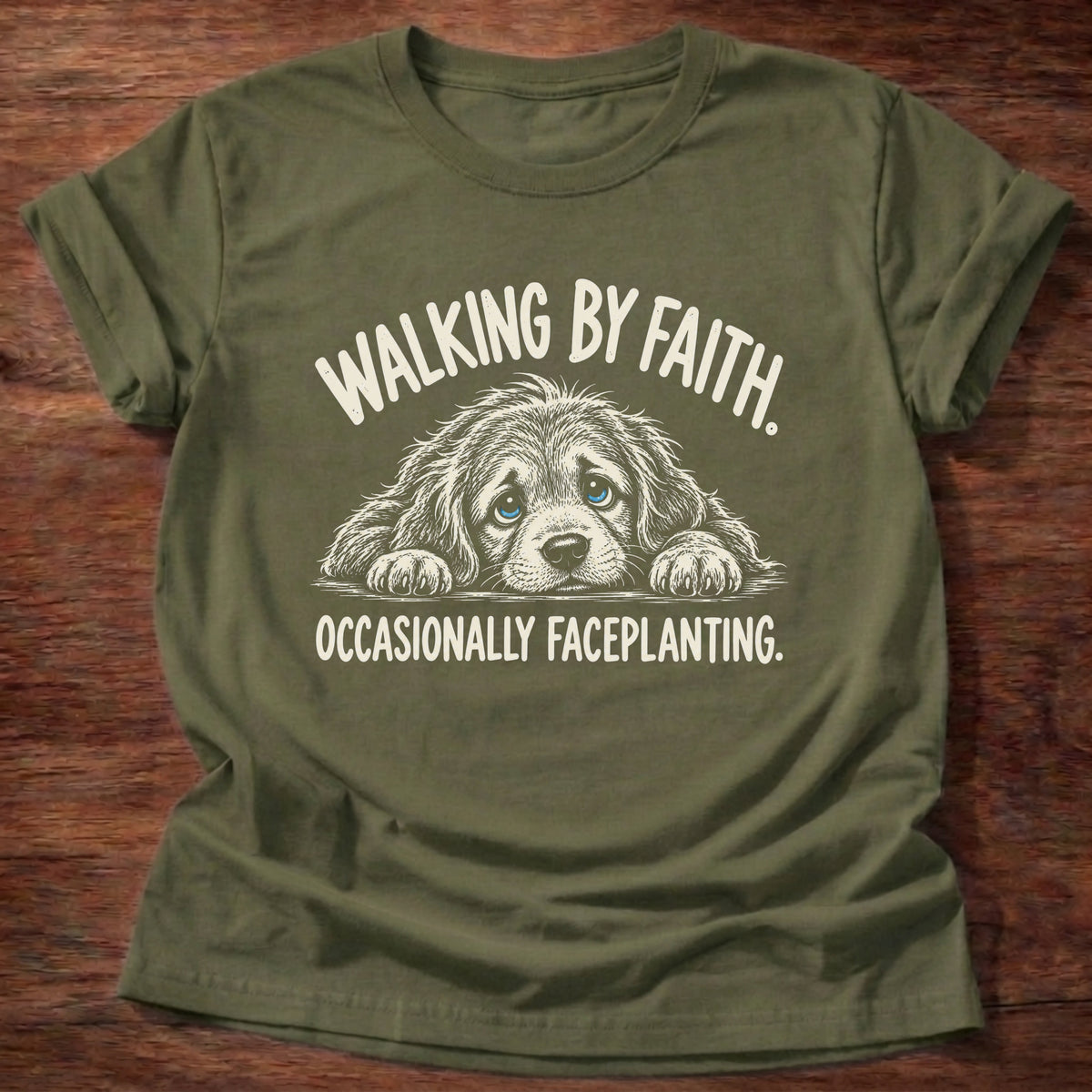 Military Green t-shirt printed with a floppy-eared puppy faceplanted on the ground graphic and “Walking by faith. Occasionally faceplanting.” 2 Corinthians 5:7 Christian shirt