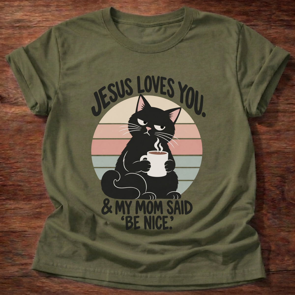 Military Green t-shirt printed with a grumpy black cat holding a steaming coffee mug in front of a retro striped sunset graphic and “Jesus loves you. & my mom said 'be nice.'” faith based gift