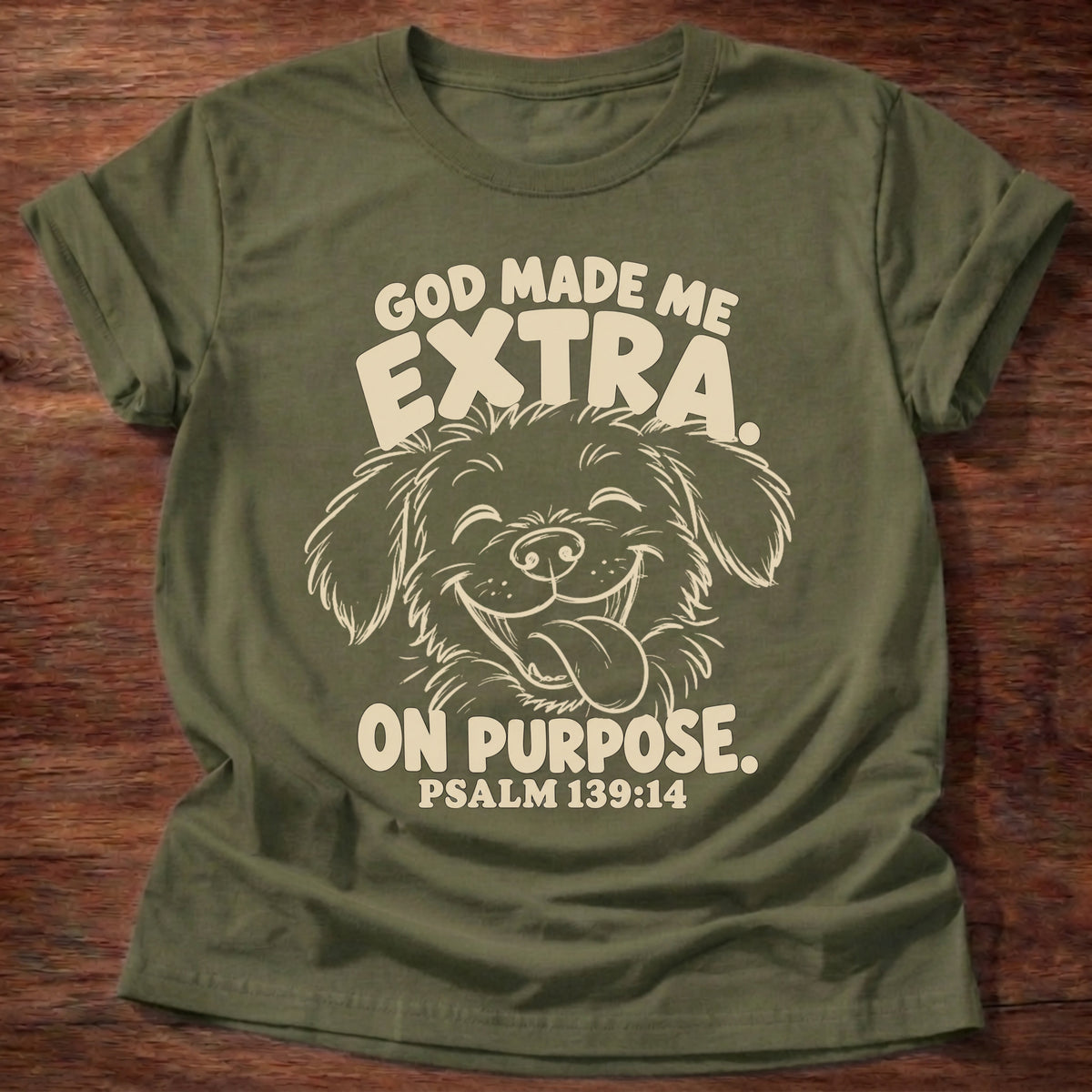 Military Green t-shirt printed with a fluffy, happy dog with its tongue out and “God made me extra. On purpose.” Psalm 139:14 Christian shirt