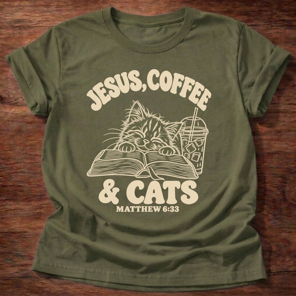 Military Green t-shirt printed with a kitten reading an open Bible beside an iced coffee and “Jesus, Coffee & Cats” Matthew 6:33 Christian shirt