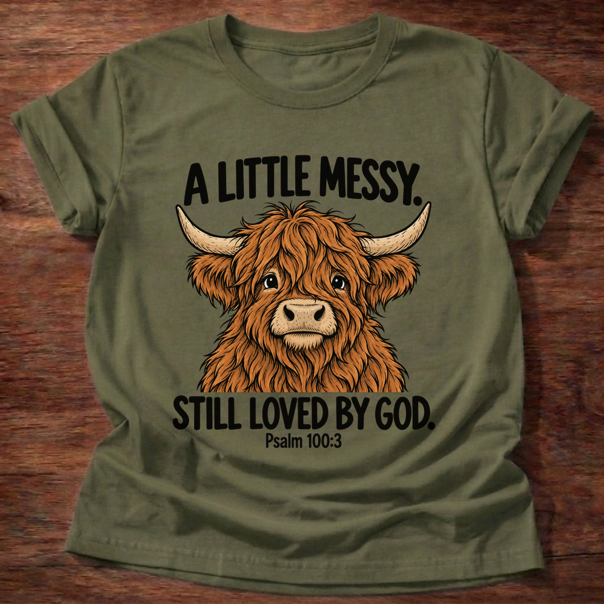 Military Green t-shirt printed with a highland cow graphic and 'A little messy. Still loved by God.' Psalm 100:3 faith based gift