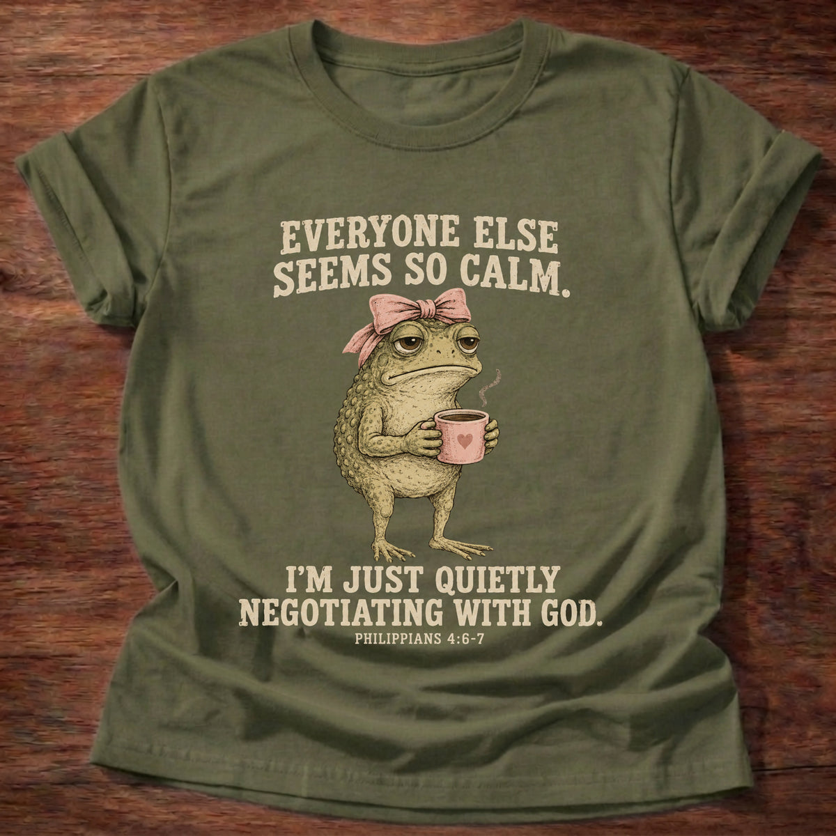 Military Green t-shirt printed with a possum holding a tea cup graphic and 'Everyone else seems so calm. I'm just quietly negotiating with God.' Philippians 4:6-7 faith based gift