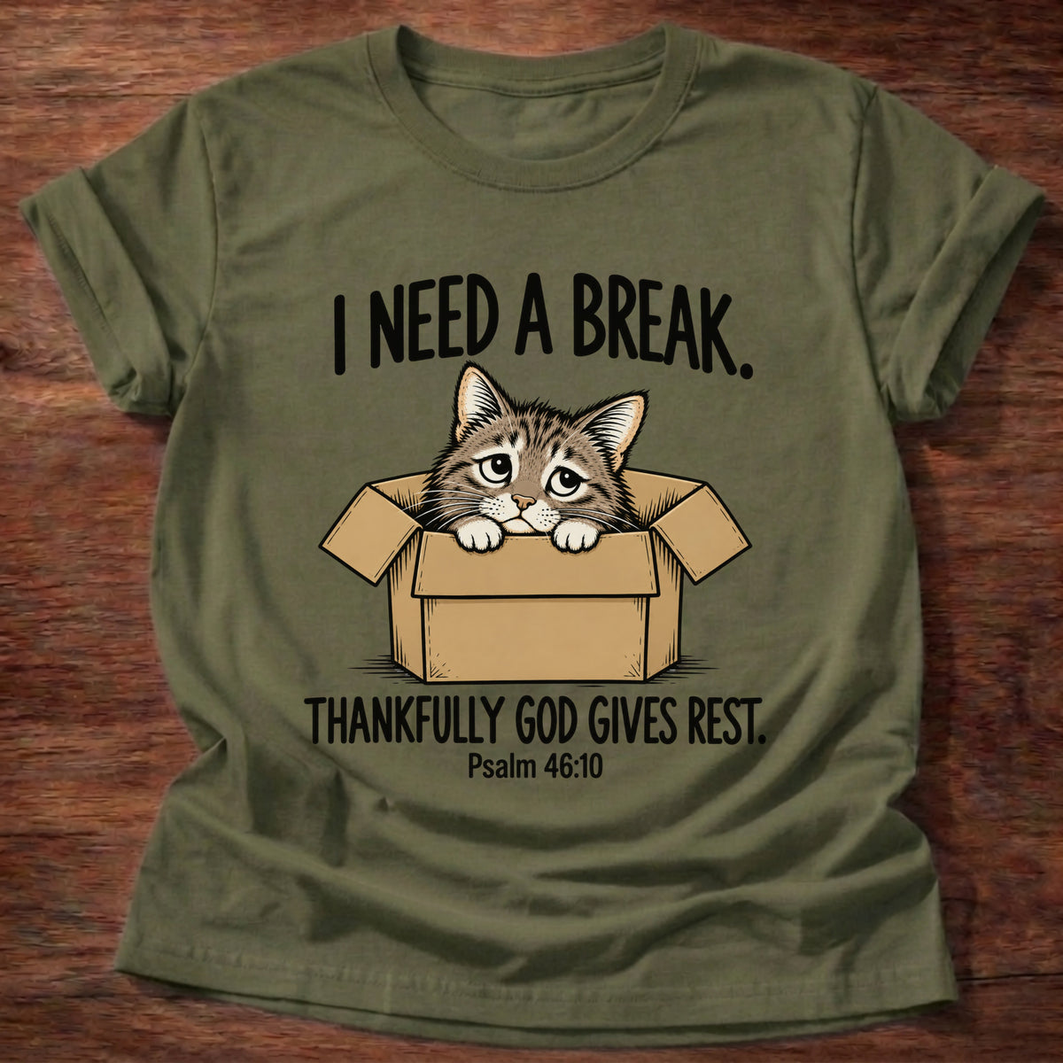 Military Green t-shirt printed with a cat curled in a cardboard box graphic and 'I need a break. Thankfully God gives rest.' Psalm 46:10 faith based gift