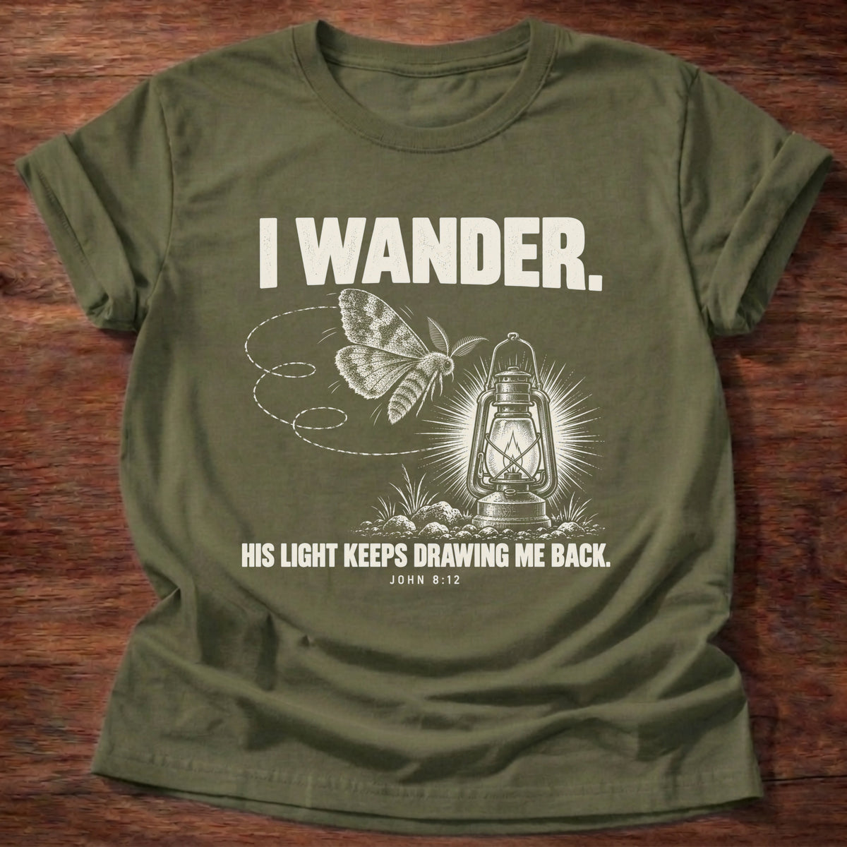 Military Green t-shirt printed with a moth circling a glowing lantern graphic and 'I wander. His light keeps drawing me back.' John 8:12 faith based gift