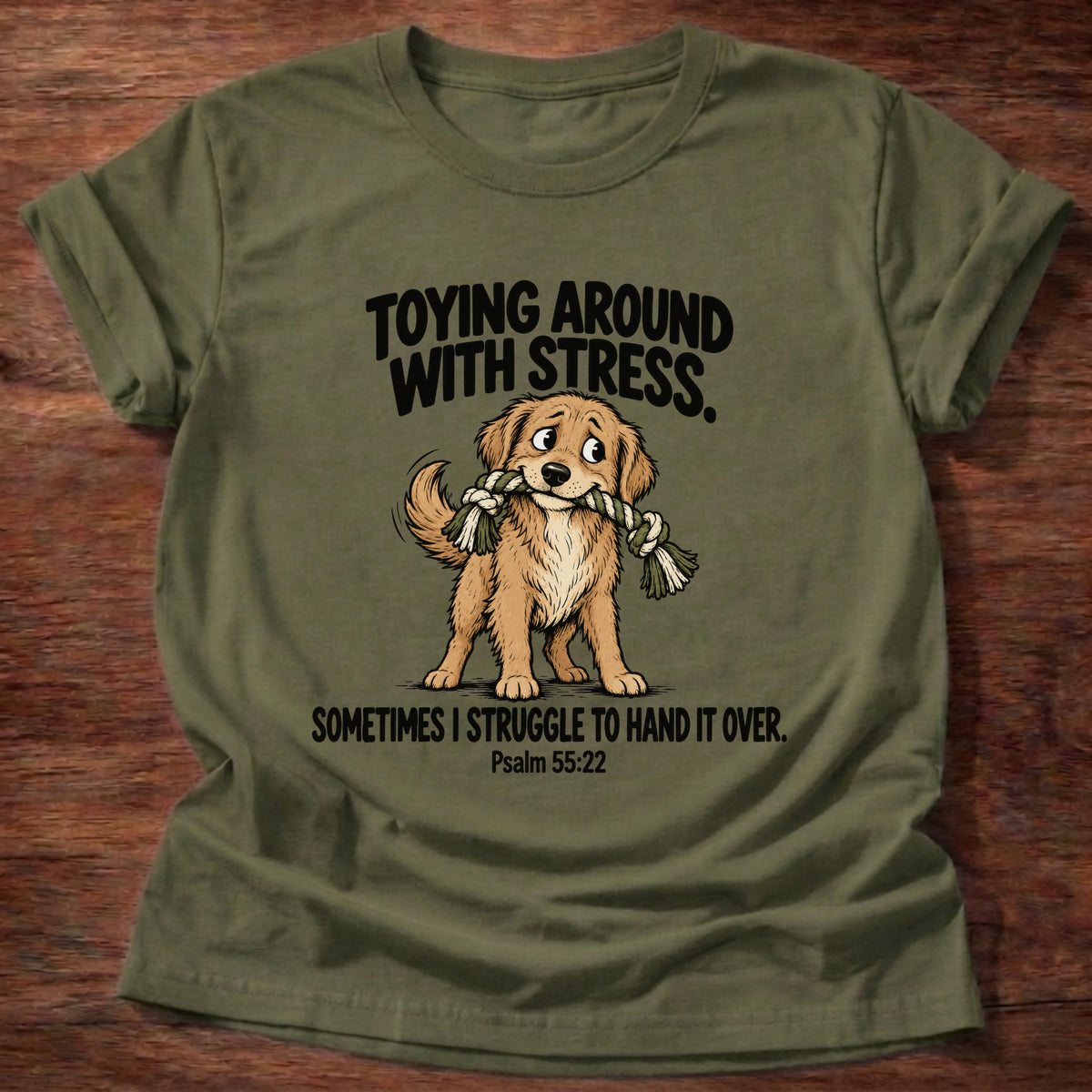 Military Green t-shirt printed with a dog tugging a rope toy graphic and 'Toying around with stress. Sometimes I struggle to hand it over.' Psalm 55:22 faith based gift
