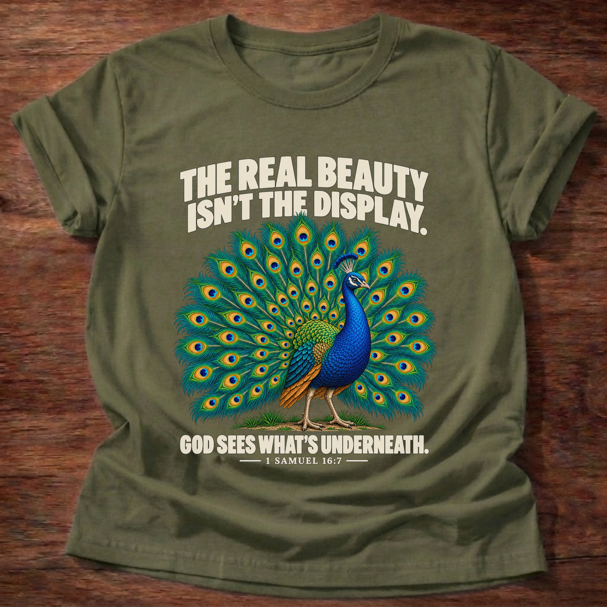 Military Green t-shirt printed with a peacock with feathers in full display graphic and 'The real beauty isn't the display. God sees what's underneath.' 1 Samuel 16:7 faith based gift